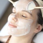 Frau während einer Classic Gesichtsbehandlung mit aufgetragener Pflegemaske in einer ästhetischen Praxis Medicare